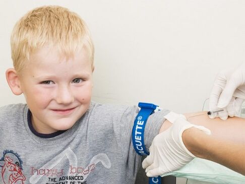 Otrok daruje kri za analizo v primeru suma okužbe s paraziti